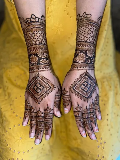 A geometric design for a baby shower, featuring diamond-shaped patterns on the back of the hands, combined with floral bands on the wrist.