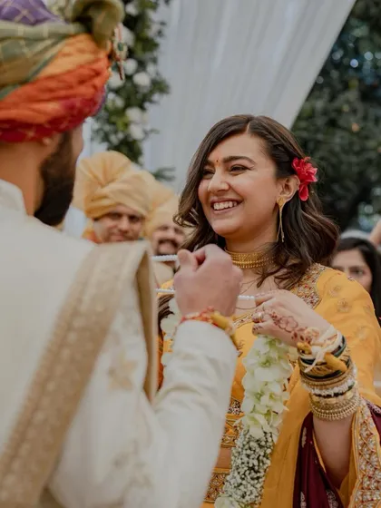 The pure, unadulterated joy on the bride's face as she playfully places the garland on her groom is a candid moment we cherish capturing.