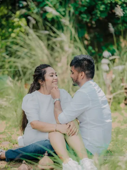 An intimate moment in a beautiful green space. The groom's gentle touch and the couple's loving gaze make this a very romantic and natural-feeling portrait.