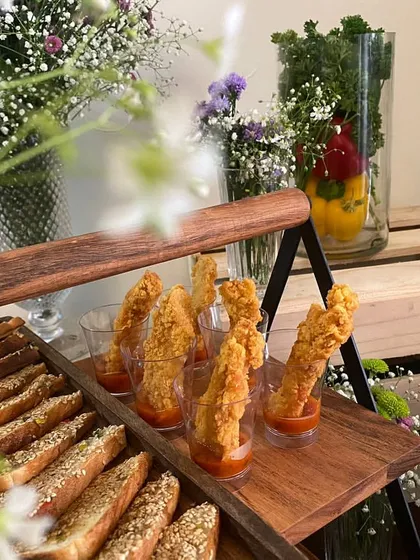 A detailed shot of our appetizer display. Here you can see crispy chicken tenders and sesame-crusted breadsticks, ready to be served at a party.
