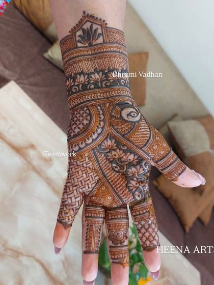 A close-up of a single back-hand, filled with dense, traditional patterns like lotuses and jaali work.