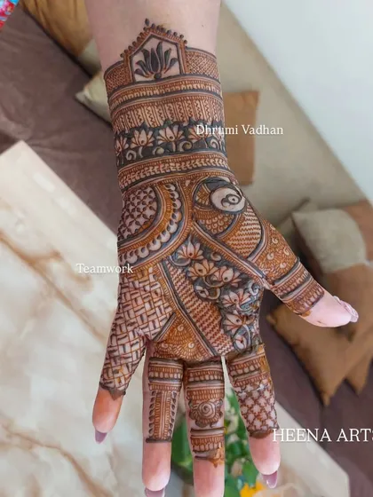 A close-up of a single back-hand, filled with dense, traditional patterns like lotuses and jaali work.