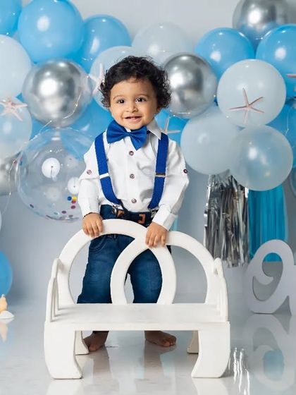 Dressed up and ready to celebrate. This little gentleman looks sharp in his bow tie and suspenders for his ocean-themed first birthday portrait.