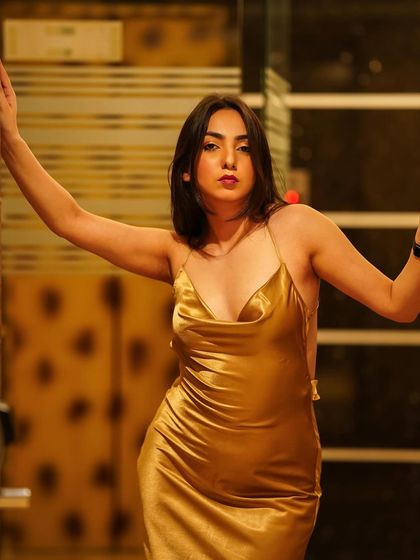 A direct, confident pose in the golden gown, showcasing its beautiful color and sheen.