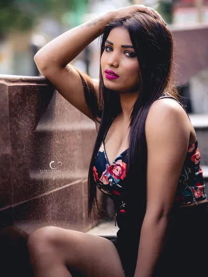 A fierce and confident portrait on outdoor steps. Her bold makeup and intense gaze create a powerful and captivating image.