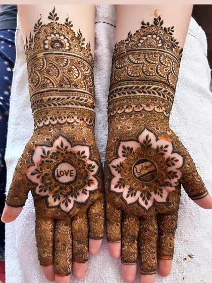 A simple word can say so much. This design features the word "LOVE" and a name hidden within beautiful floral mandalas on the palms.