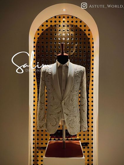 A white tuxedo jacket with intricate all-over white embroidery, displayed in my studio. This is a stunning option for a groom who wants a luxurious, textured look.