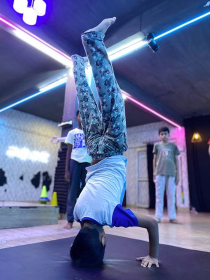 A student practices a headstand, an excellent exercise for building core stability, arm strength, and balance. We teach inversions like this with a focus on proper alignment.