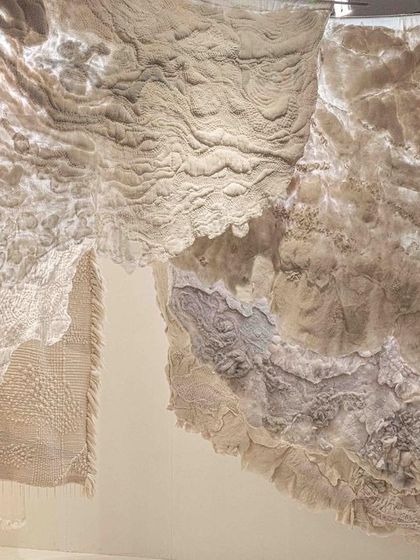 A detail of the layered fabrics in the 'Sleep Sense' installation. The backlit, deckled-edged panels feel like floating clouds, creating a soothing, dream-like experience for the viewer.