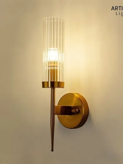 This modern sconce features a ribbed glass cylinder set against a brushed brass fixture. The design plays with texture and transparency, offering a clean and elegant lighting solution for hallways, bathrooms, or reading nooks.
