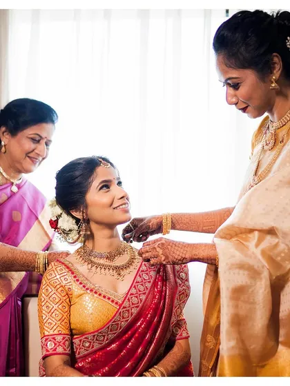 A beautiful moment from a two-states wedding. Sneha is being adorned by her family, her minimal makeup looking flawless and elegant.
