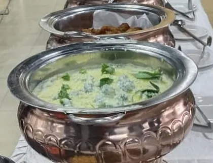 A creamy and delicious vegetable dish, likely a Malai Kofta or a vegetable korma, served in our elegant copper chafing dish. We specialize in a wide range of vegetarian North Indian curries.