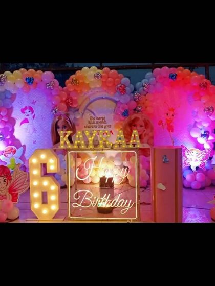 An elaborate doll and fairy-themed 6th birthday party, featuring multiple character cutouts, large balloon arches, and light-up numbers.