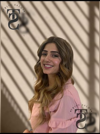 A happy client smiling with her new airbrush balayage. Her radiant look is a testament to a transformation that not only looks great but feels great too.