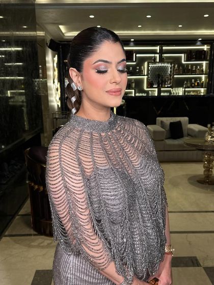 A close-up of the model, showing how the sleek hair and soft glam makeup complement the stylish braid.