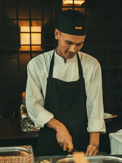 A smiling chef chops ingredients, reflecting the positive energy of our team.