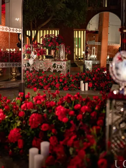 A sea of red roses. For this event, we used hundreds of roses to create a lush, immersive floral experience, with mirrors reflecting the sea of red for an even more dramatic effect.