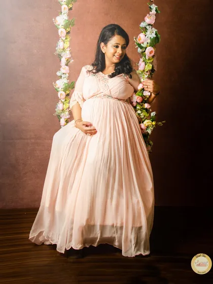 To add a touch of whimsy to your shoot, we have unique props like this beautiful floral swing. It creates a dreamy, romantic setting for solo portraits in one of our flowing maternity gowns.
