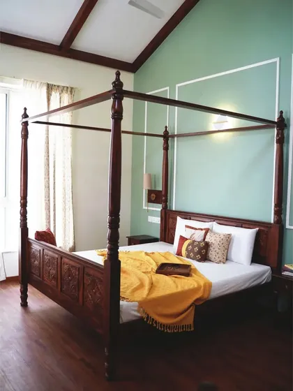The centerpiece of a master bedroom, this magnificent four-poster bed is handcrafted from solid Sheesham wood. The detailed carvings on the headboard and the elegantly turned posts evoke a timeless, colonial charm, promising serene nights and beautiful mornings.