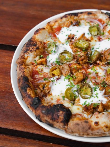 Another look at the BBQ Chicken Pizza, showing the beautiful char on the crust and the even distribution of toppings.