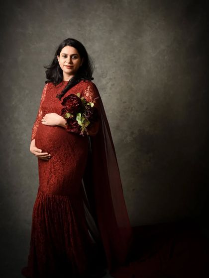 A classic standing portrait holding a bouquet. The cape-like trail of the gown adds a touch of elegance and drama to the silhouette.
