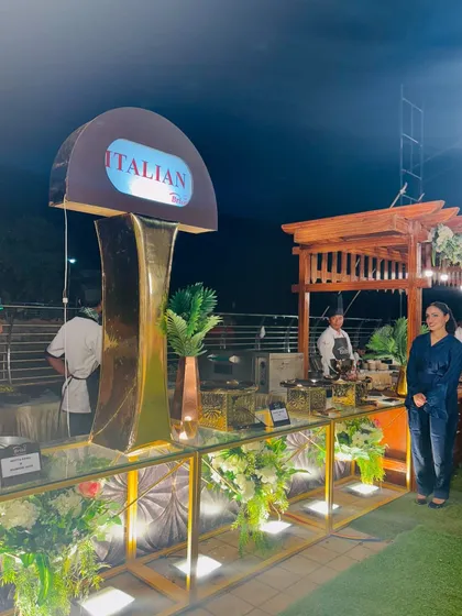 A guest poses by the stylish Italian food counter, highlighting the premium ambiance I create.