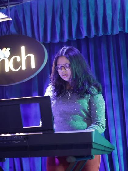 A student pianist performs her piece under the professional stage lighting at our RIR event. We ensure every student gets their moment to shine.