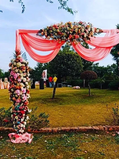 A beautiful designer entry gate is essential for a wedding. This arch, made with lush pink drapes and dense columns of fresh carnations and roses, provides a stunning welcome for guests and a gorgeous photo opportunity.
