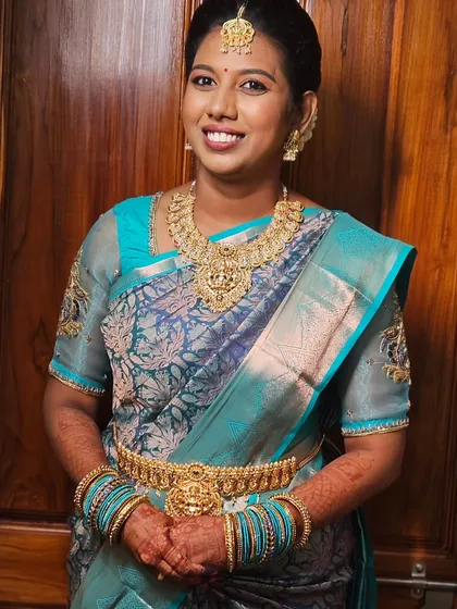 A simple and elegant look with a beautiful blue silk saree and traditional gold jewelry.