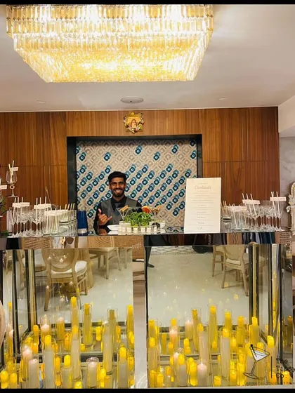 An elegant and grand bar setup featuring a mirrored base filled with candles. The reflection creates a stunning visual effect, making the bar a sophisticated and warm focal point.