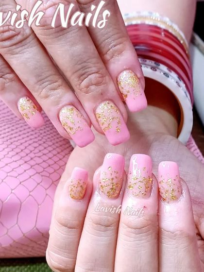 A festive look with pink square-shaped nails and a cascade of gold foil glitter, perfect for weddings and celebrations.