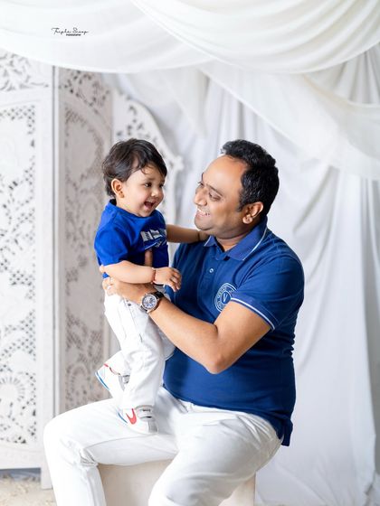 A heartwarming photo of a father and son sharing a laugh. The simple background keeps the focus on their happy interaction.