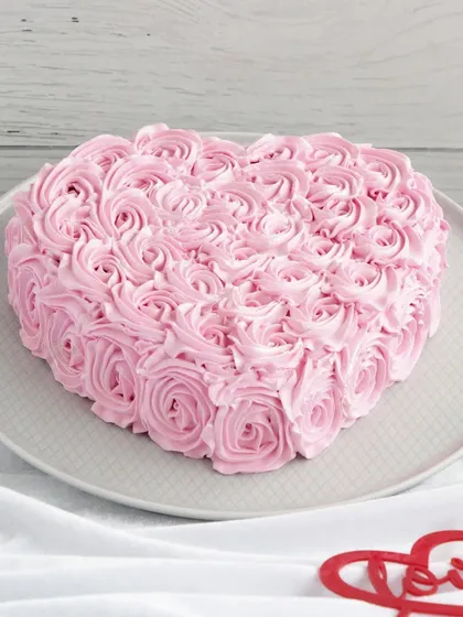 A heart-shaped cake covered in beautiful pink rosettes. This design is a classic way to express love for Valentine's Day, an anniversary, or just because.