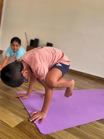 Even complex poses like Bakasana, or crow pose, become accessible with practice and courage. This little yogi is building arm strength and balance, showing incredible focus.