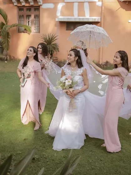 The bridesmaids helping with the bride's veil in a beautiful garden setting. A perfect shot from a destination wedding.