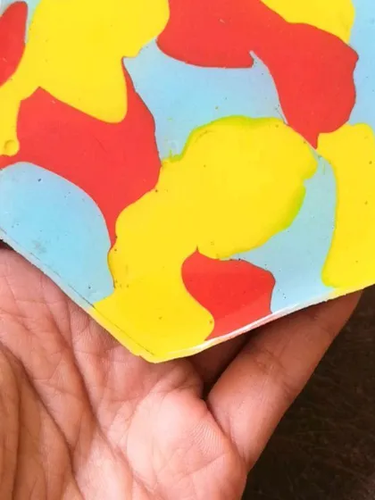 Holding a coaster with a fun, camouflage-like pattern. Each one is a mini painting you can hold in your hand.