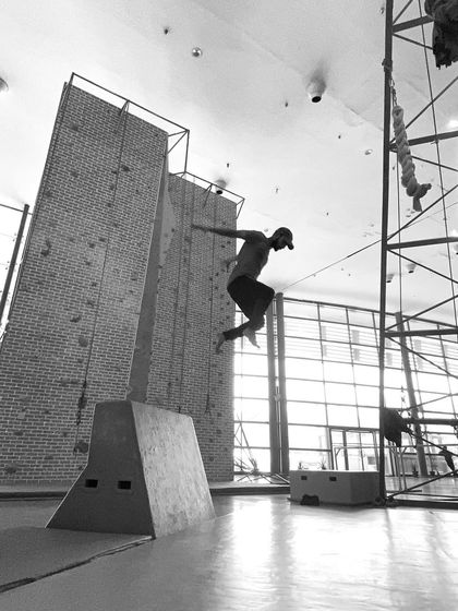 This dynamic shot shows a practitioner clearing an obstacle with a powerful jump. Our training helps you develop the explosive strength needed for these kinds of movements.