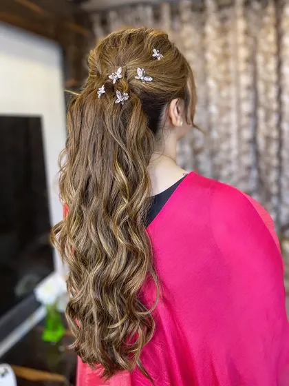 A textured ponytail adorned with delicate butterfly clips, a whimsical and romantic choice.