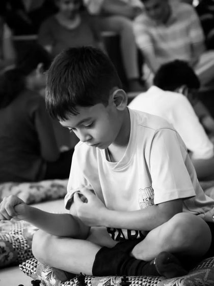 The quiet concentration of a young player. Our classes help develop focus and patience, essential skills both on and off the chessboard.