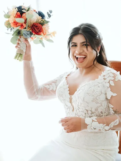 A moment of pure joy from the bride, celebrating with her bouquet in hand.