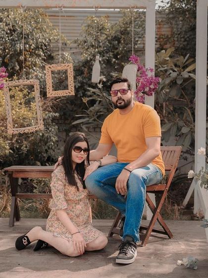 A classic portrait from a garden pre-wedding shoot, with the couple posing against a beautifully decorated backdrop.