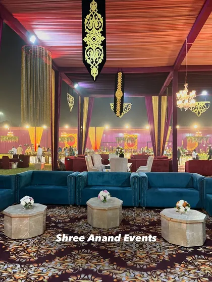 A beautifully composed shot of a lounge area with teal sofas, set against a backdrop of purple and gold drapes and hanging decor.