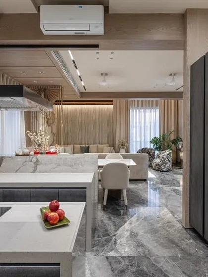 This view shows the kitchen's connection to the living space, highlighting the open and airy feel of the home. The tall pantry units provide ample storage.