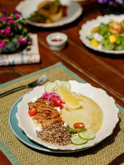 A sun-drenched plate of grilled chicken, quinoa, and hummus, a nourishing and soulful lunch option.