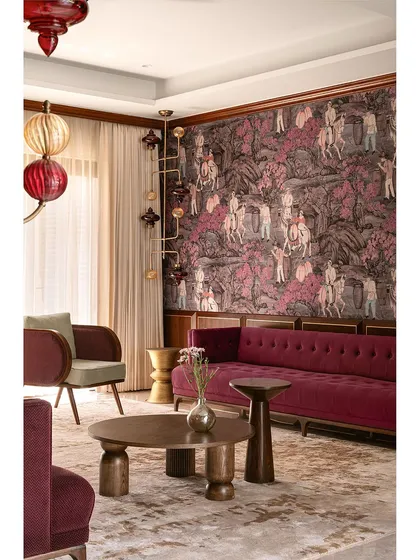 We love to weave a narrative of texture and layers, transforming a home into a vibrant, artful canvas. Here, a bold magenta velvet sofa and dramatic wallpaper create a symphony of color that redefines contemporary elegance and makes the formal living room a visual delight.