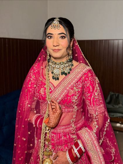 A full view of the bride, looking absolutely stunning. The makeup is balanced to look perfect with her entire ensemble.