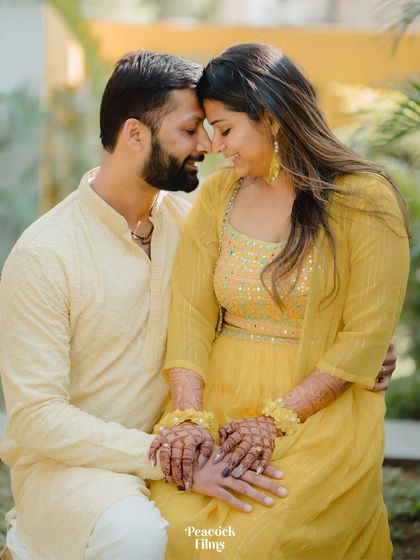 A tender moment between the couple, their foreheads touching. This portrait captures the intimacy and affection they share amidst the Haldi festivities.