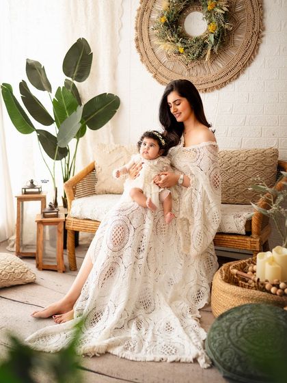A mother and her adorable, chubby-cheeked baby girl in a beautiful, light-filled setting.