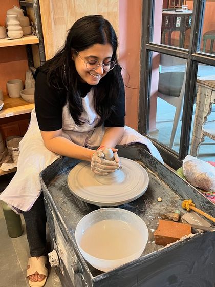 That look of happy concentration. A student finds her center as she learns to center the clay on the wheel.
