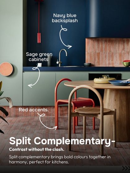 A split-complementary scheme offers contrast without the clash. Here, sage green cabinets are paired with a navy blue backsplash and red accents, bringing bold colors together in harmony.